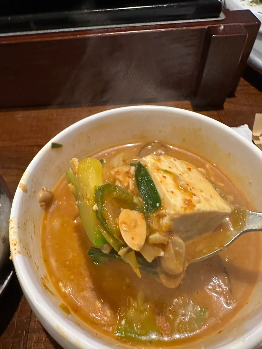 A spoonful of the stew's broth lifted up