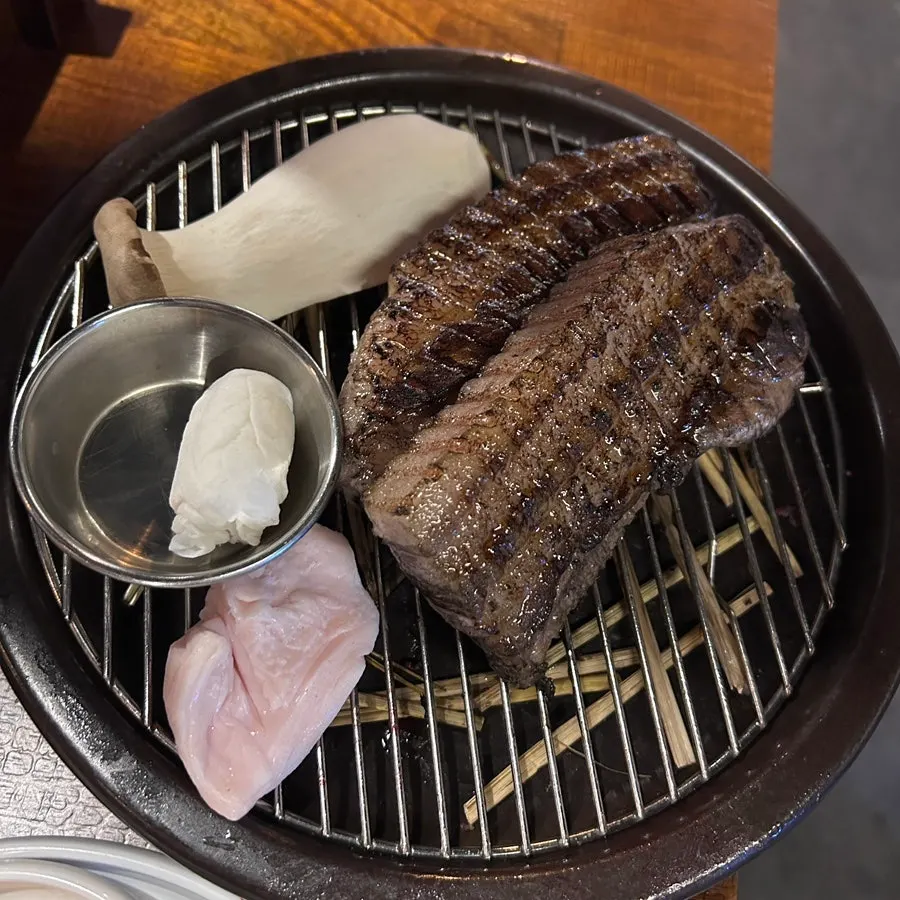 Two servings of deeply colored, pre-seared straw-fired pork belly