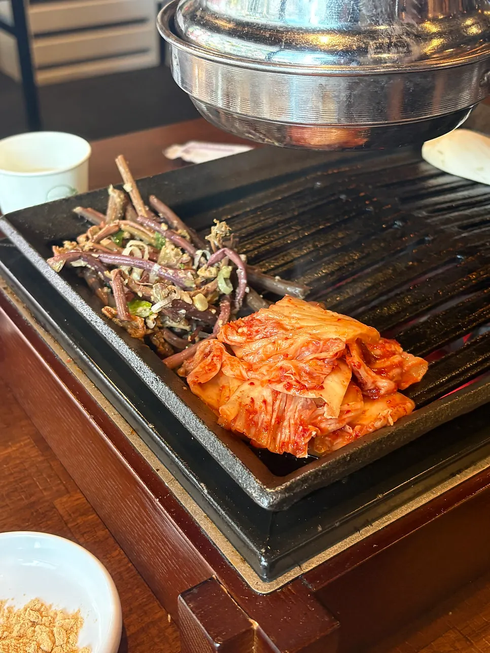 Straw-fired meat being grilled one final time at the table