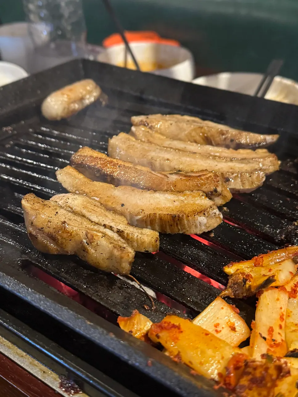 Pork jowl grilling on the barbecue
