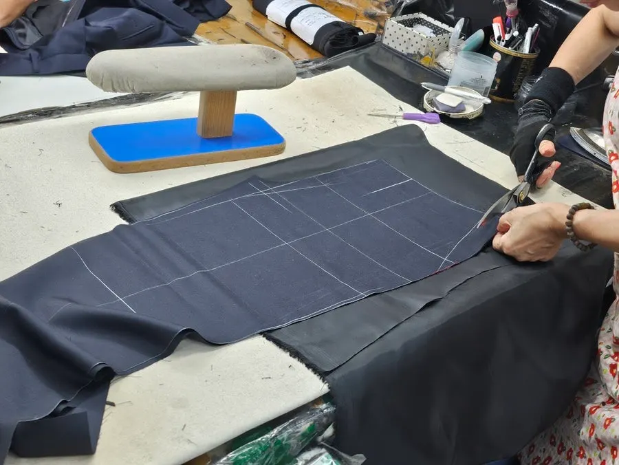 Cut fabric stacked on a worktable at the in-house factory