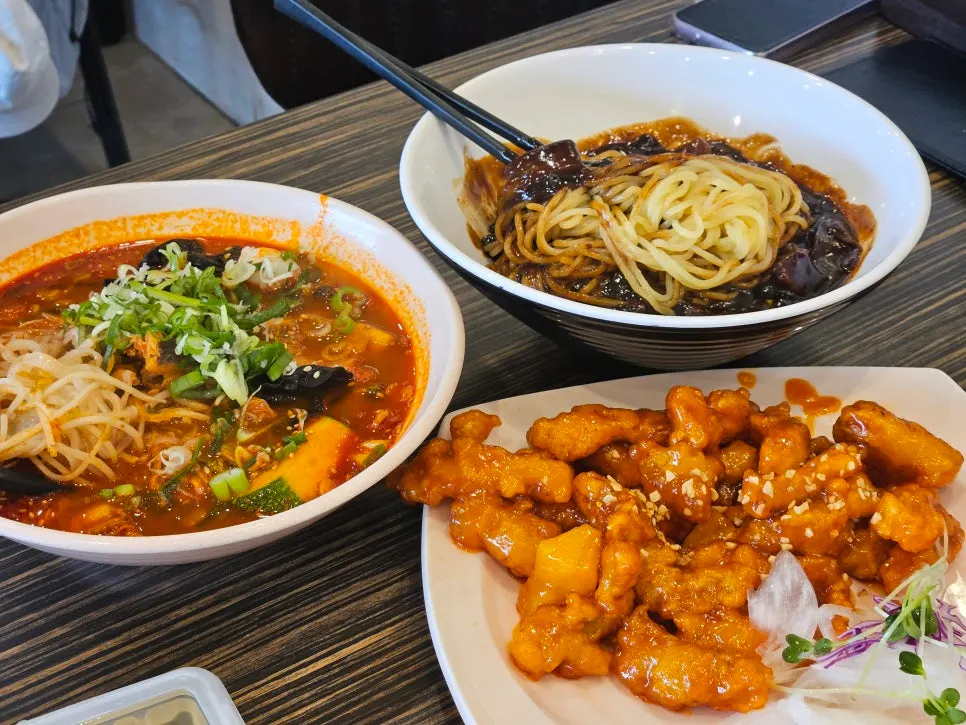 Table spread with jjamppong, jjajangmyeon, and Sichuan tangsuyuk