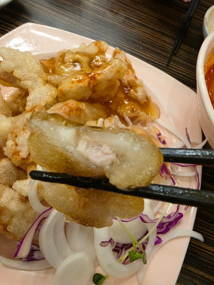 Cross-section of sweet and sour pork dipped in sauce