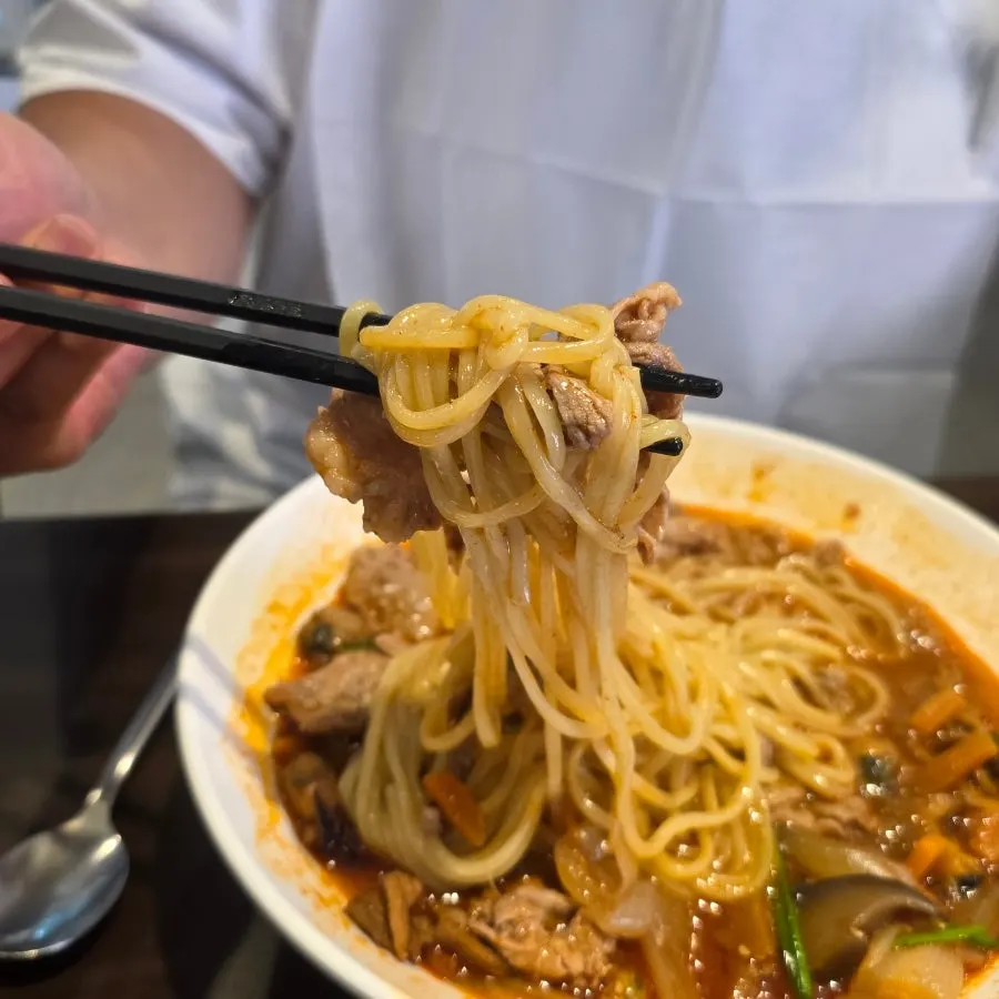 Jjambbong noodles lifted with chopsticks