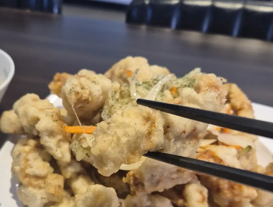 Tangsuyuk topped with shredded fried zucchini, onion, and carrot