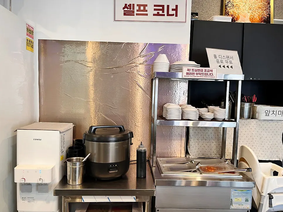 Self-serve corner with side dishes, rice, tongs and aprons