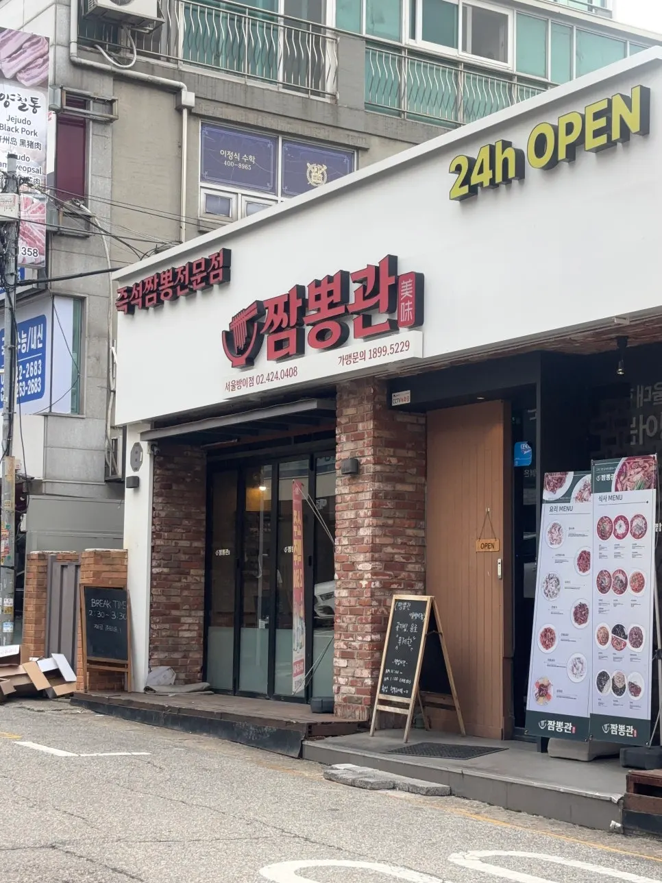 벽돌 외관과 입간판이 있는 짬뽕관 서울방이점 입구