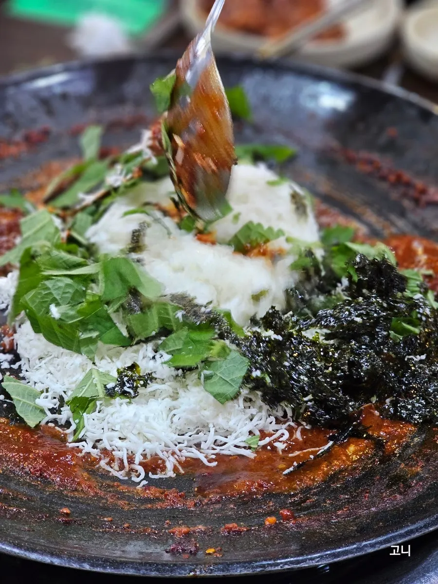 Fried rice being cooked in the leftover sauce on the hot plate
