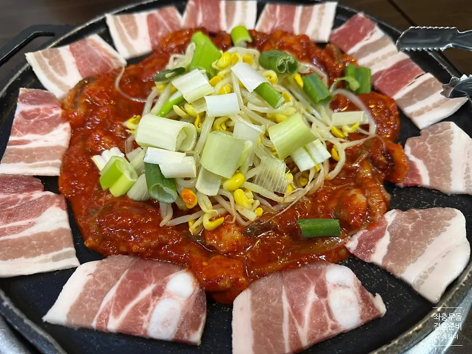 철판 테두리에 둘러진 삼겹살과 가운데 양념 쭈꾸미