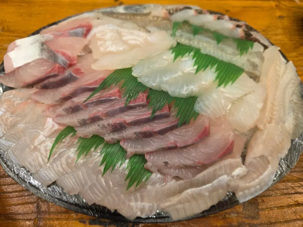 A piece of sashimi with wasabi and soy sauce