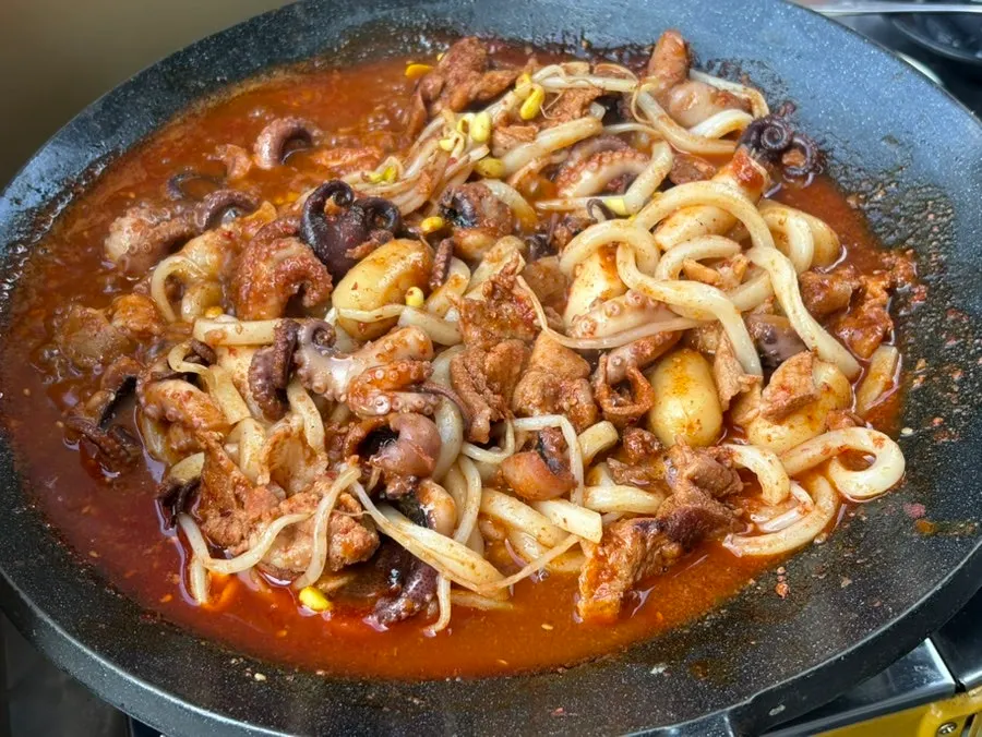Hot plate with sauce-soaked udon noodles and jjusam