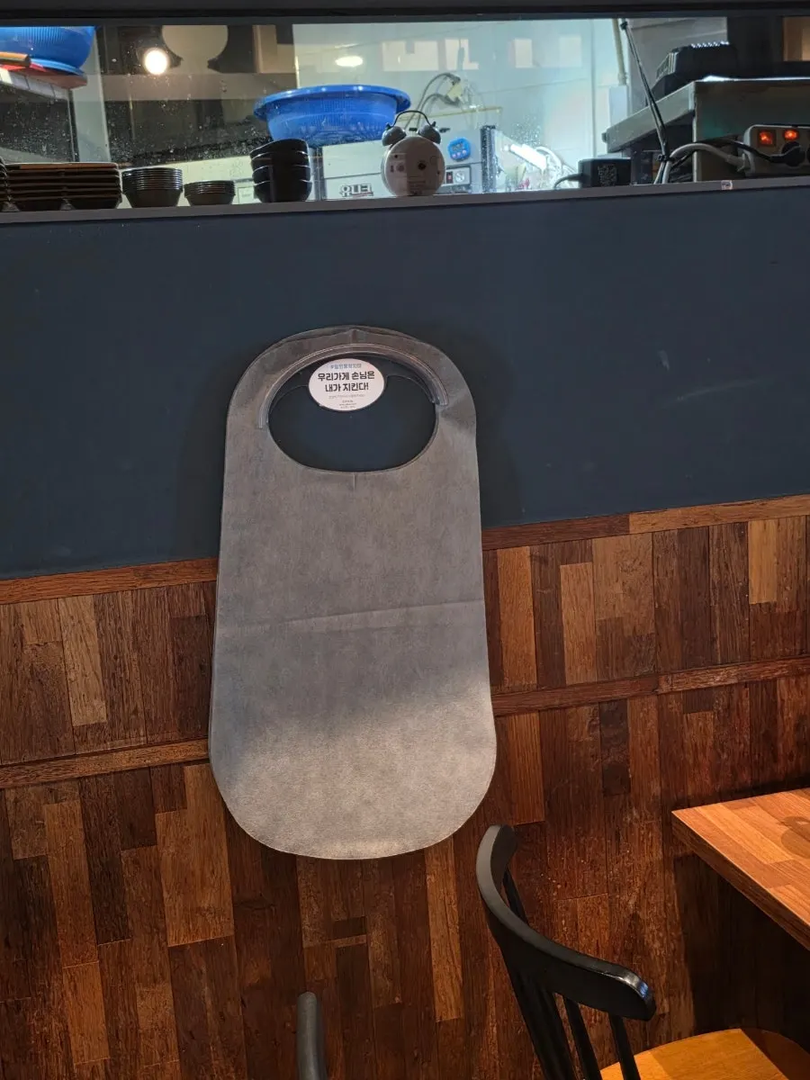 Interior tables and disposable aprons at Jju Baksa Magok Branch