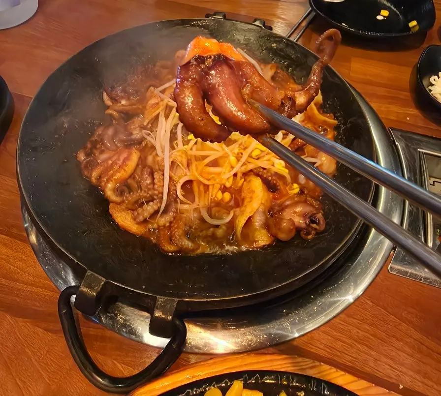 Octopus and pork belly cooking in spicy sauce