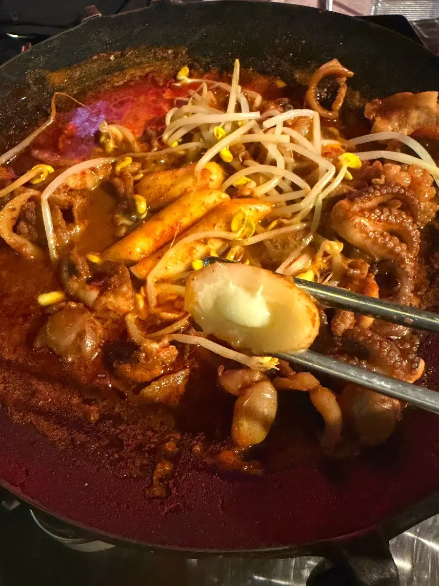 Finished hot plate jjusamsae topped with bean sprouts