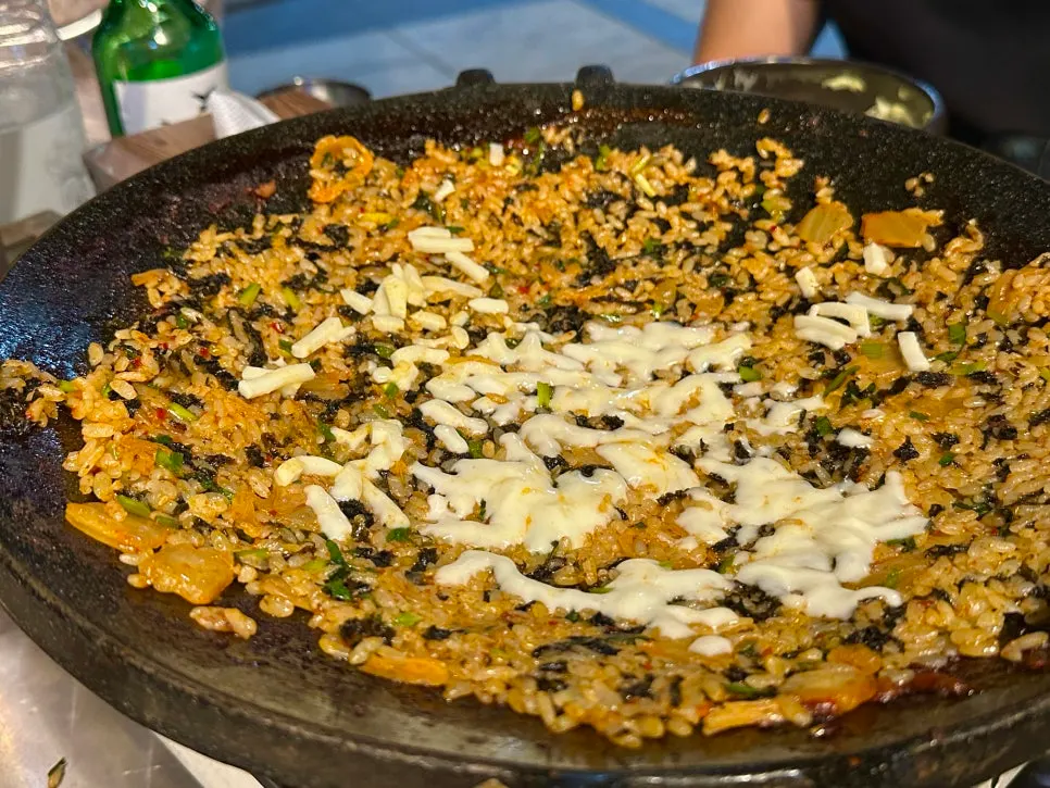 Cheese fried rice being stir-fried on the hot plate
