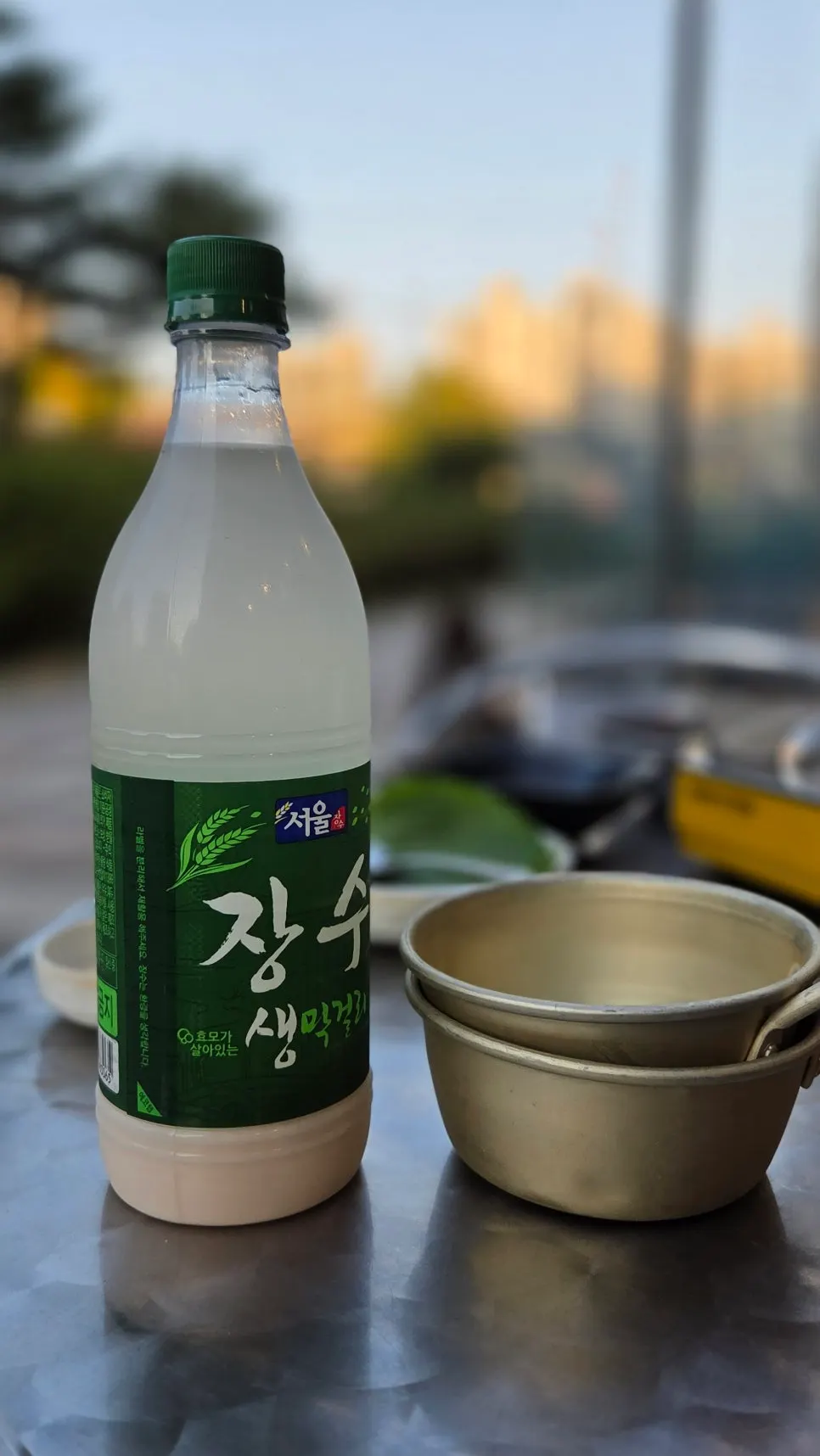 철판 쭈꾸미와 게살 계란찜, 주먹밥이 놓인 야외 테이블