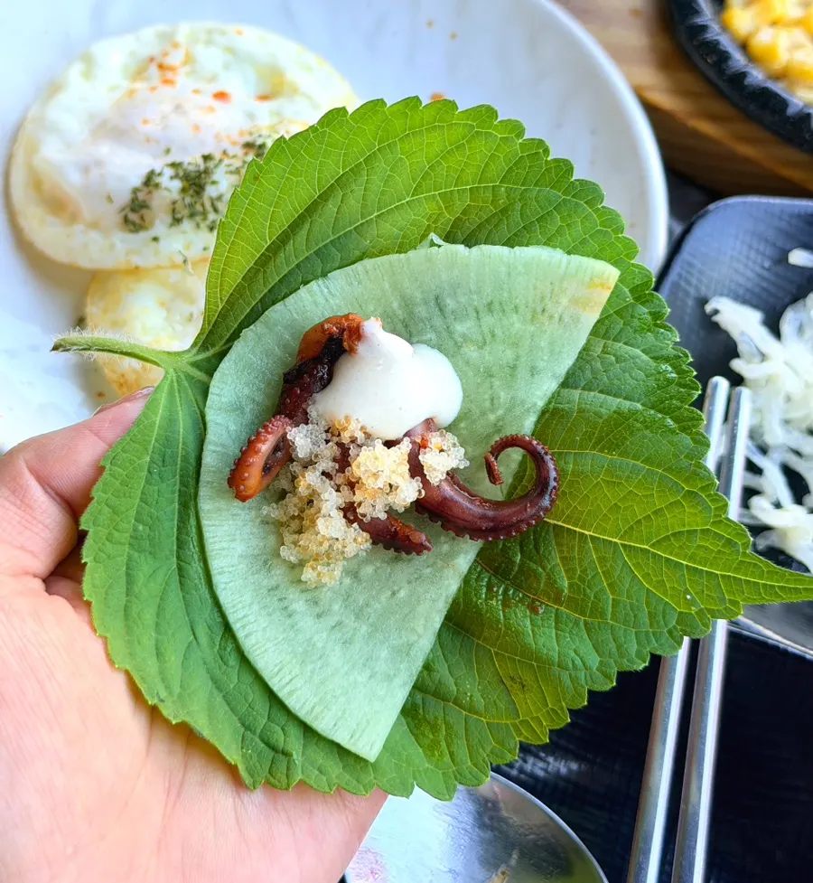 Octopus ssam wrap topped with flying fish roe and peanut sauce
