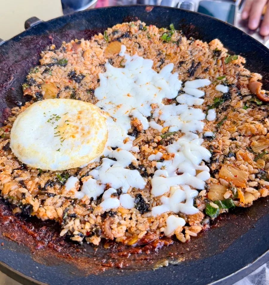 Staff member stir-frying octopus fried rice on the hot plate