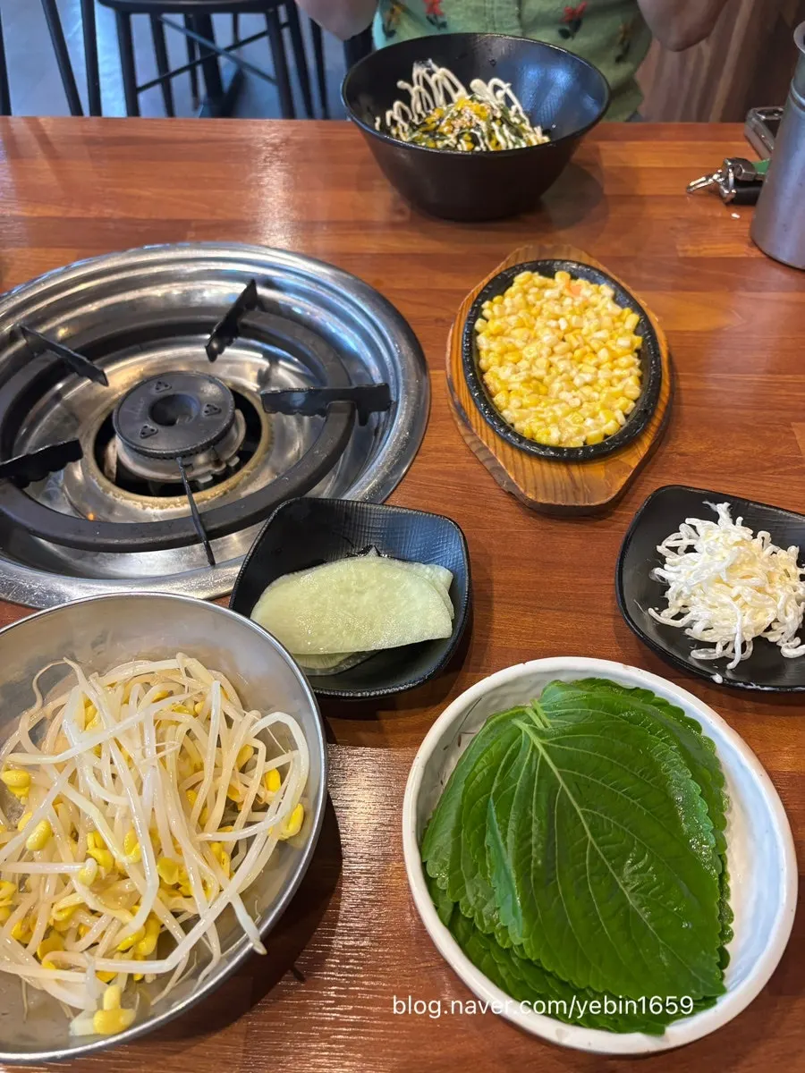 Side dish spread with perilla leaves, bean sprouts, and radish kimchi