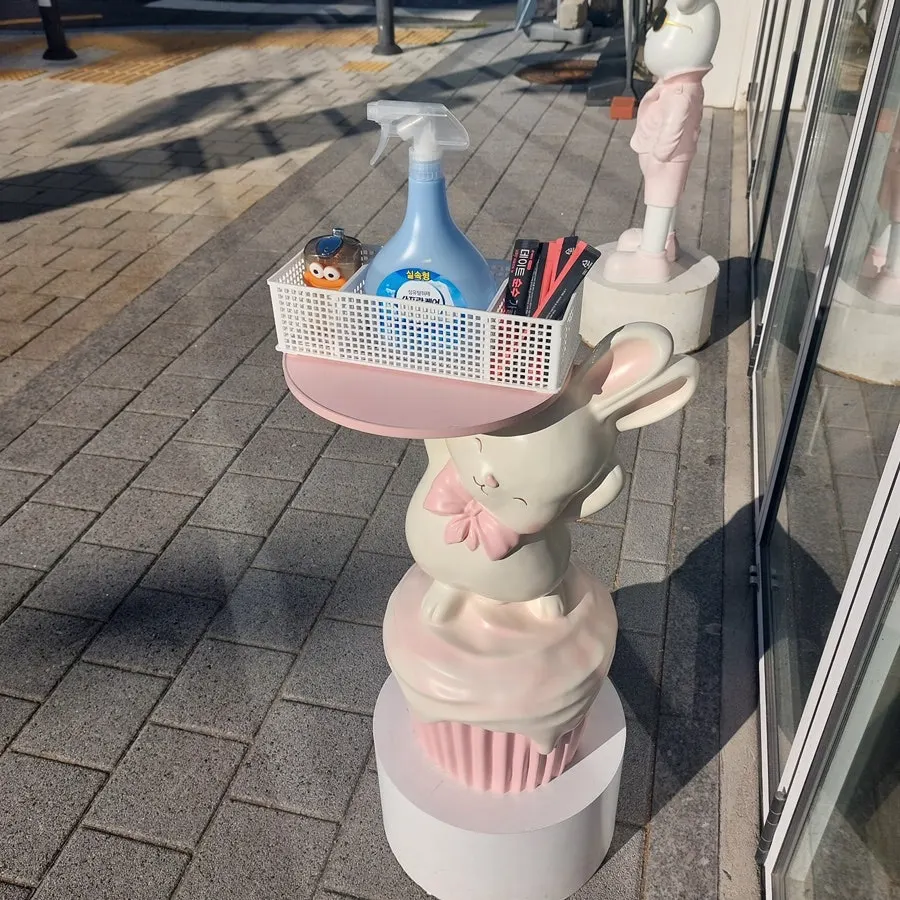 Rabbit statue by the entrance holding floss and mouthwash