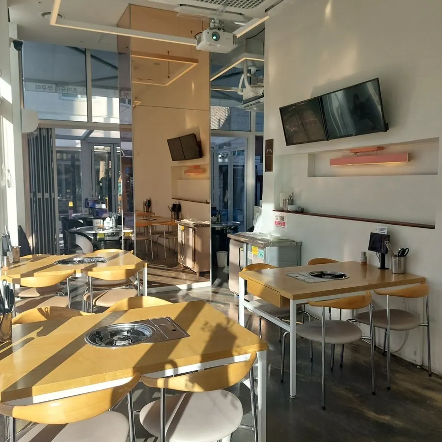 White-and-wood interior with four-person tables along the window