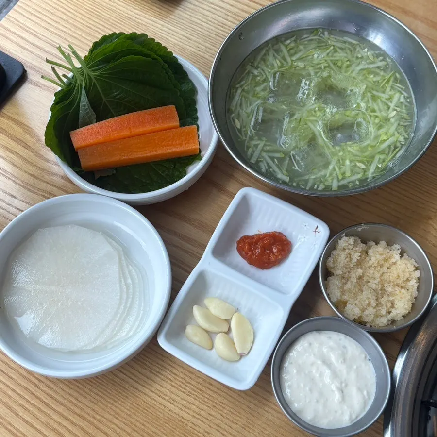Table setting with lettuce wraps and cold cucumber soup