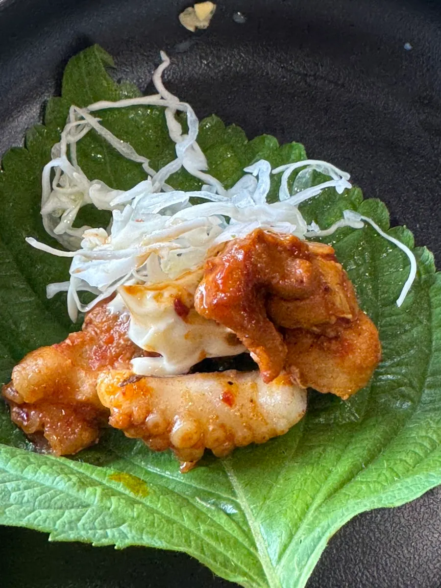 A perilla leaf wrap with jjukkumi and mayo