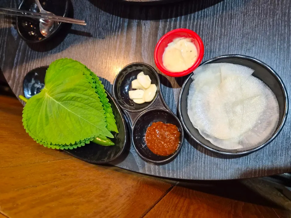 Basic side dishes of perilla leaves, garlic, pickled radish, and ssamjang