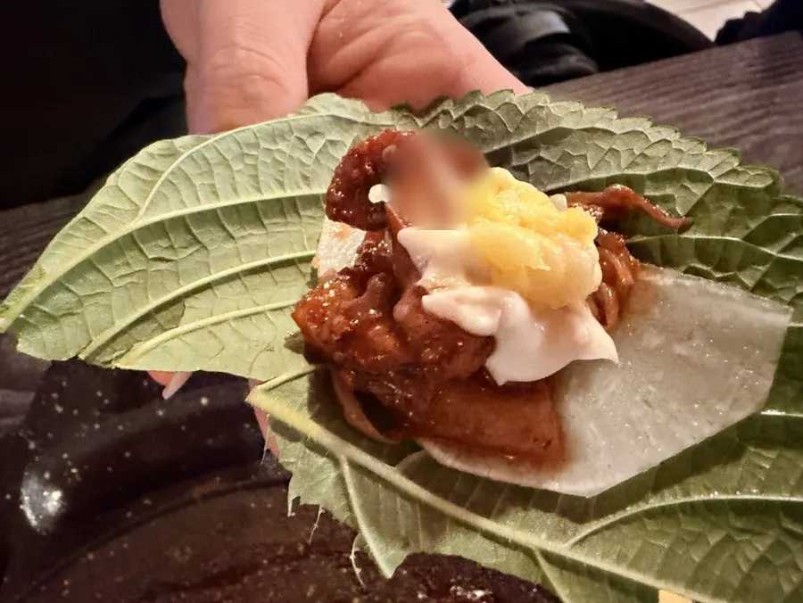 Octopus wrap topped with enoki mushrooms and cooked garlic