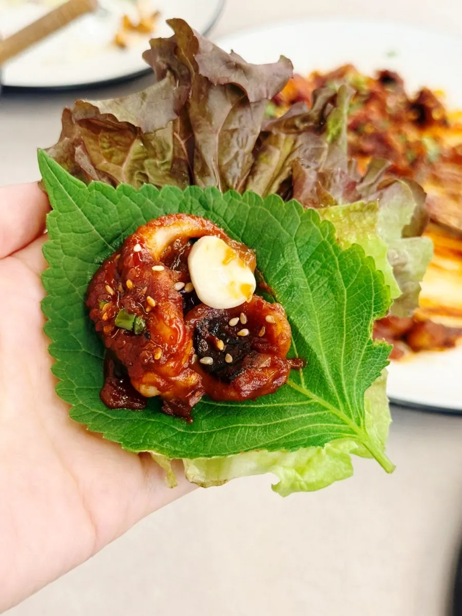 Spicy jjukkumi placed on top of wrap vegetables