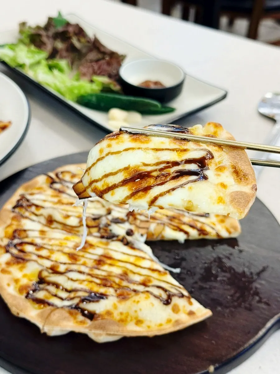 A slice of pizza topped with jjukkumi