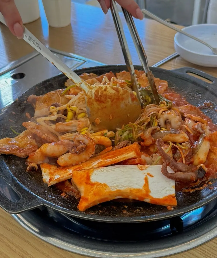 Staff stir-frying jjuksam in the pan