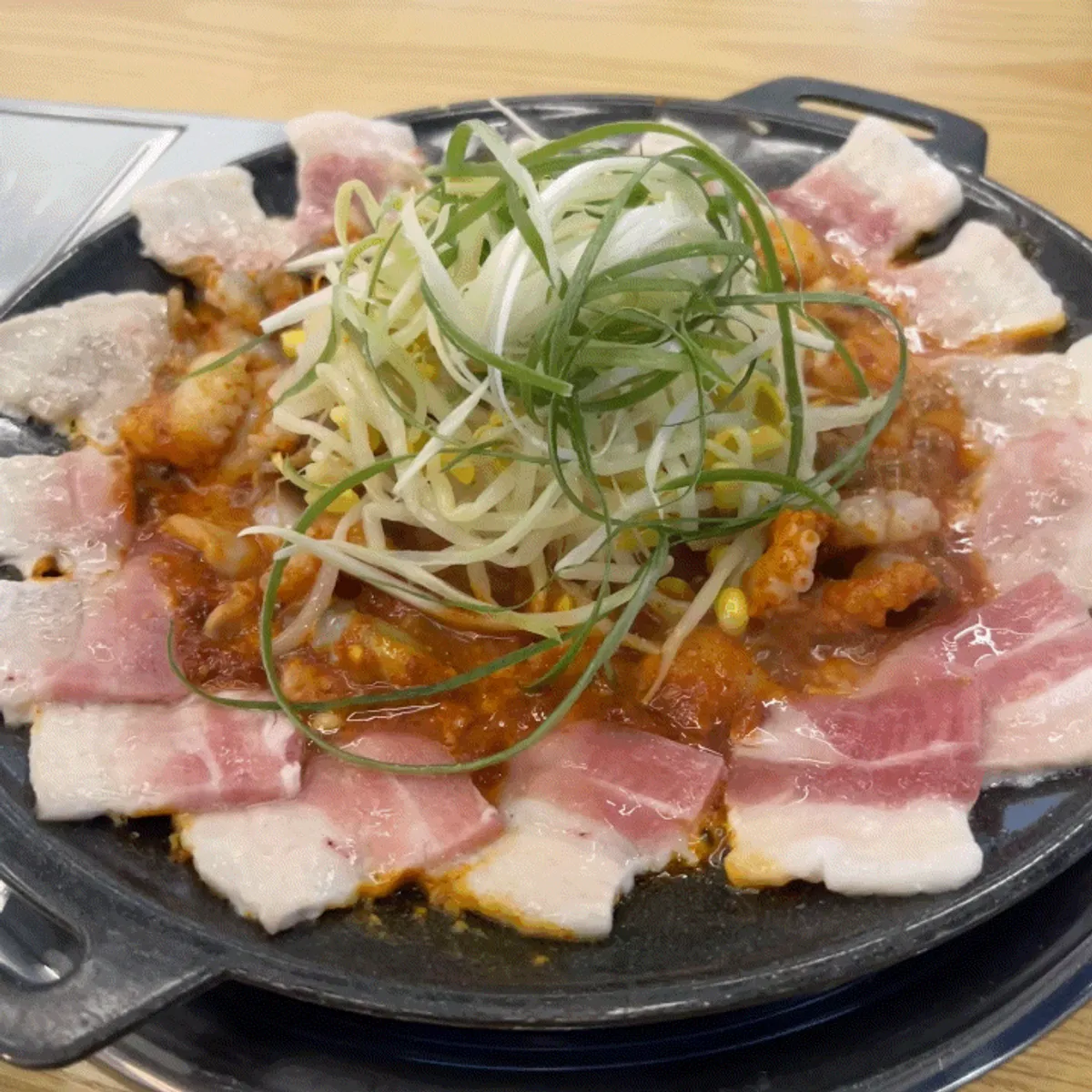 Two servings of jjukkumi-samgyeopsal piled high on the pan