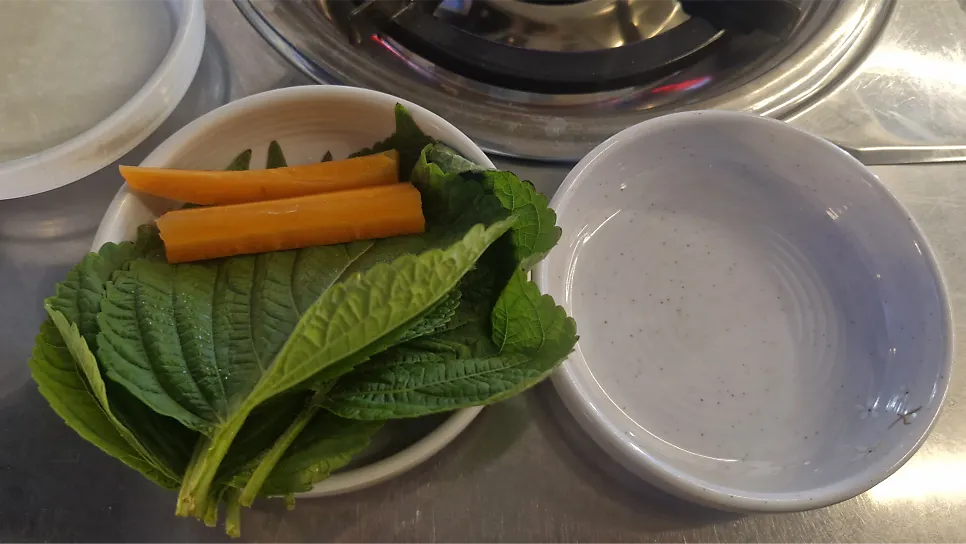 Side dishes of lettuce, garlic, and ranch sauce on the table