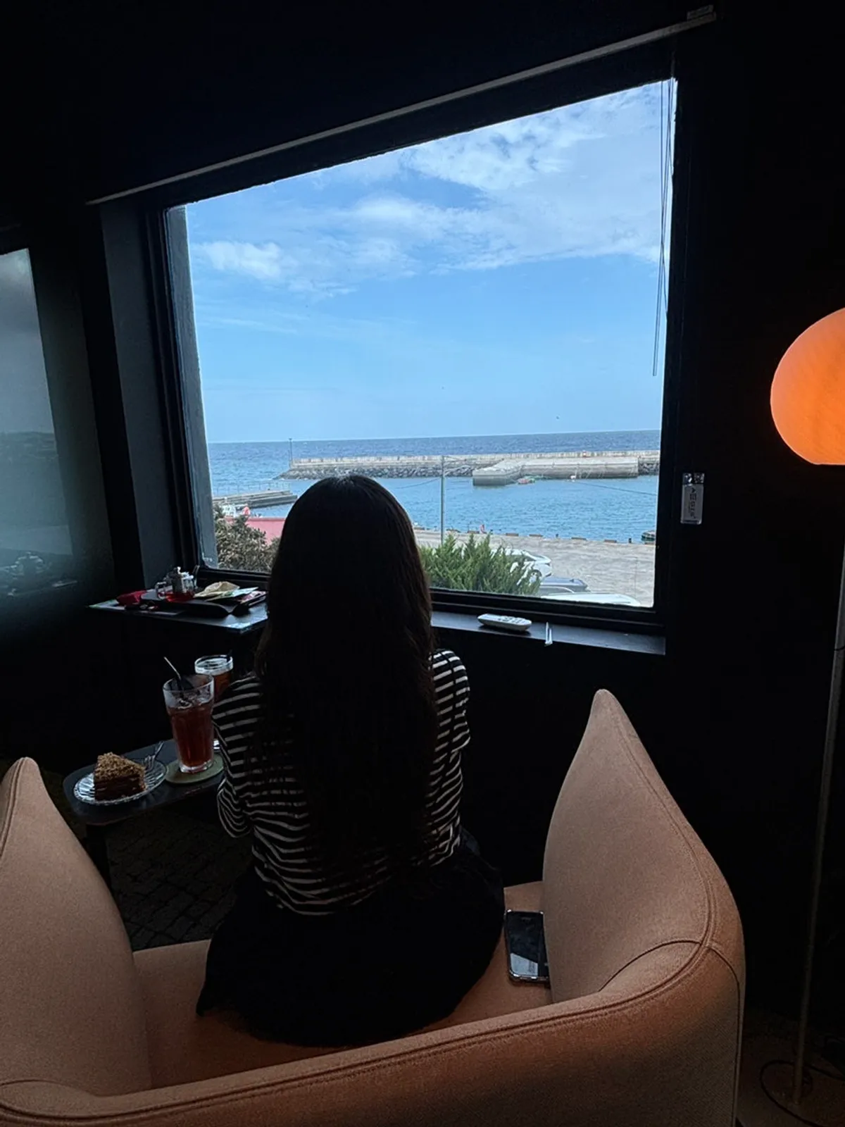 A café visit relaxing while looking out at the Jeju sea