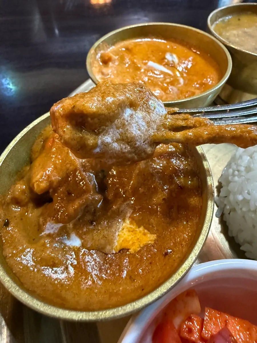Scooping up curry from the tray