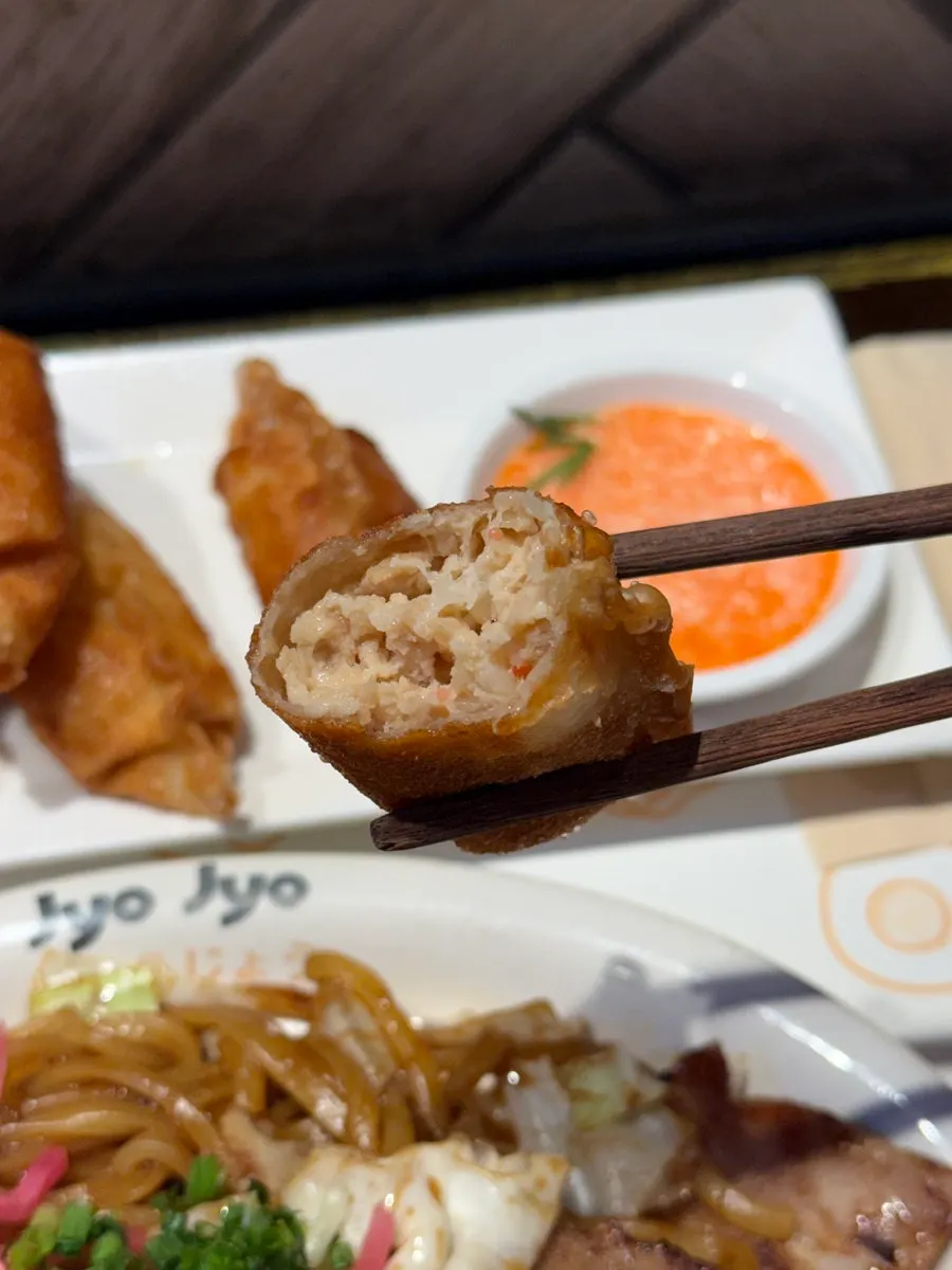 Cross-section of mentaiko gyoza picked up with chopsticks