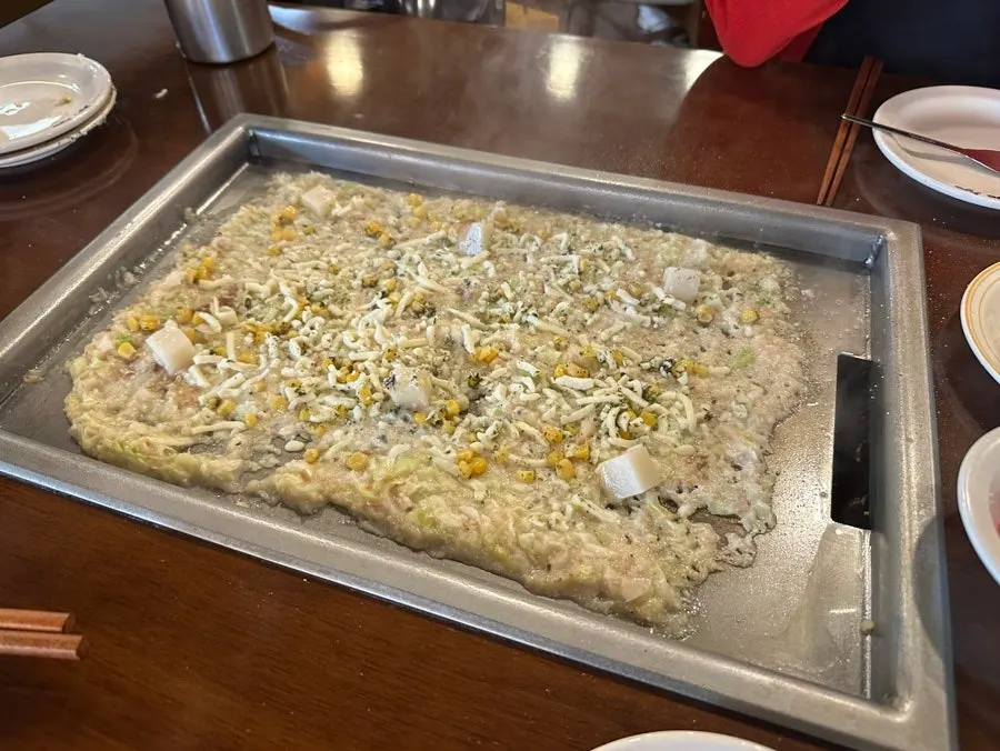 Monjayaki spread out wide on the griddle