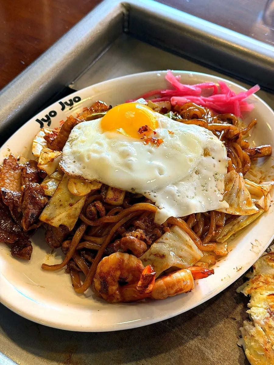 Okonomiyaki grilling on the hot plate next to the timer