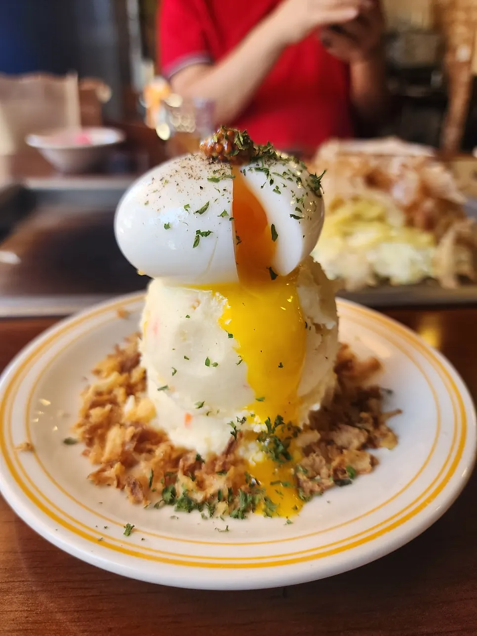 Waterfall potato topped with soft-boiled egg and onion flakes
