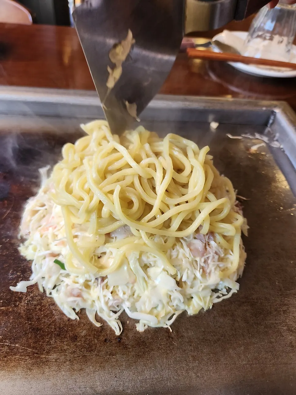Jojo okonomiyaki batter being cooked on the teppan