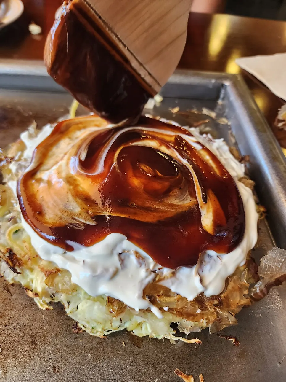 Okonomiyaki brushed with sauce and mayonnaise