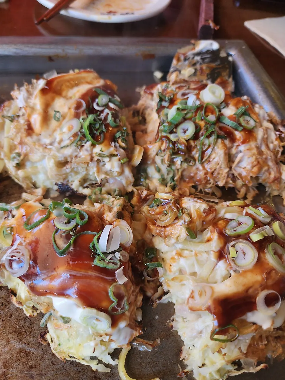Okonomiyaki cut into four pieces with a spatula
