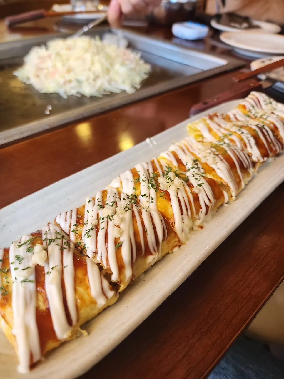 Donpeyaki plate drizzled with sauce in a wave pattern