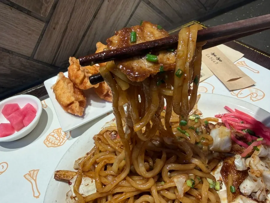 Close-up of yakisoba topped with scallions and ginger shreds