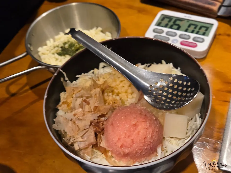 Staff member chopping monjayaki ingredients table-side