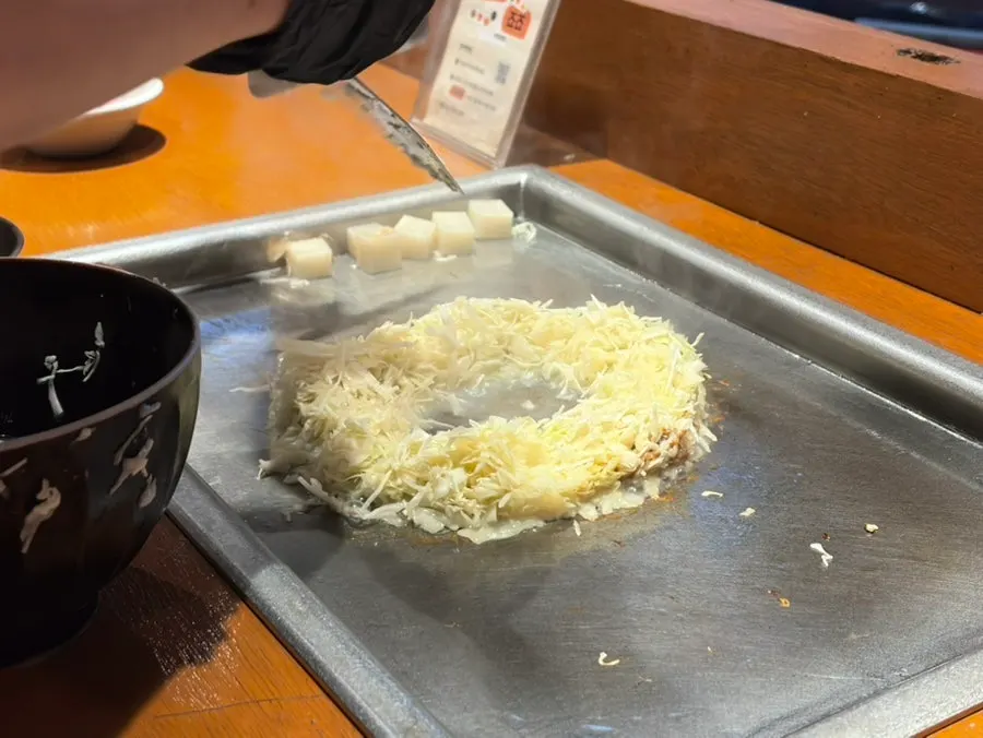 Mentaiko monjayaki ingredients cooking on the griddle