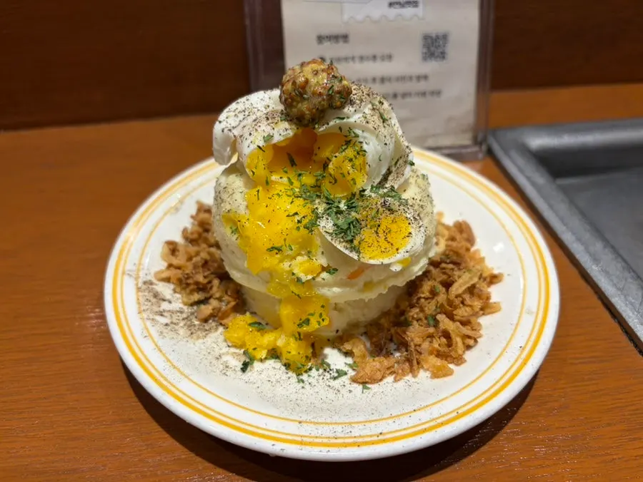 Volcano potato topped with soft-boiled egg and onion chips