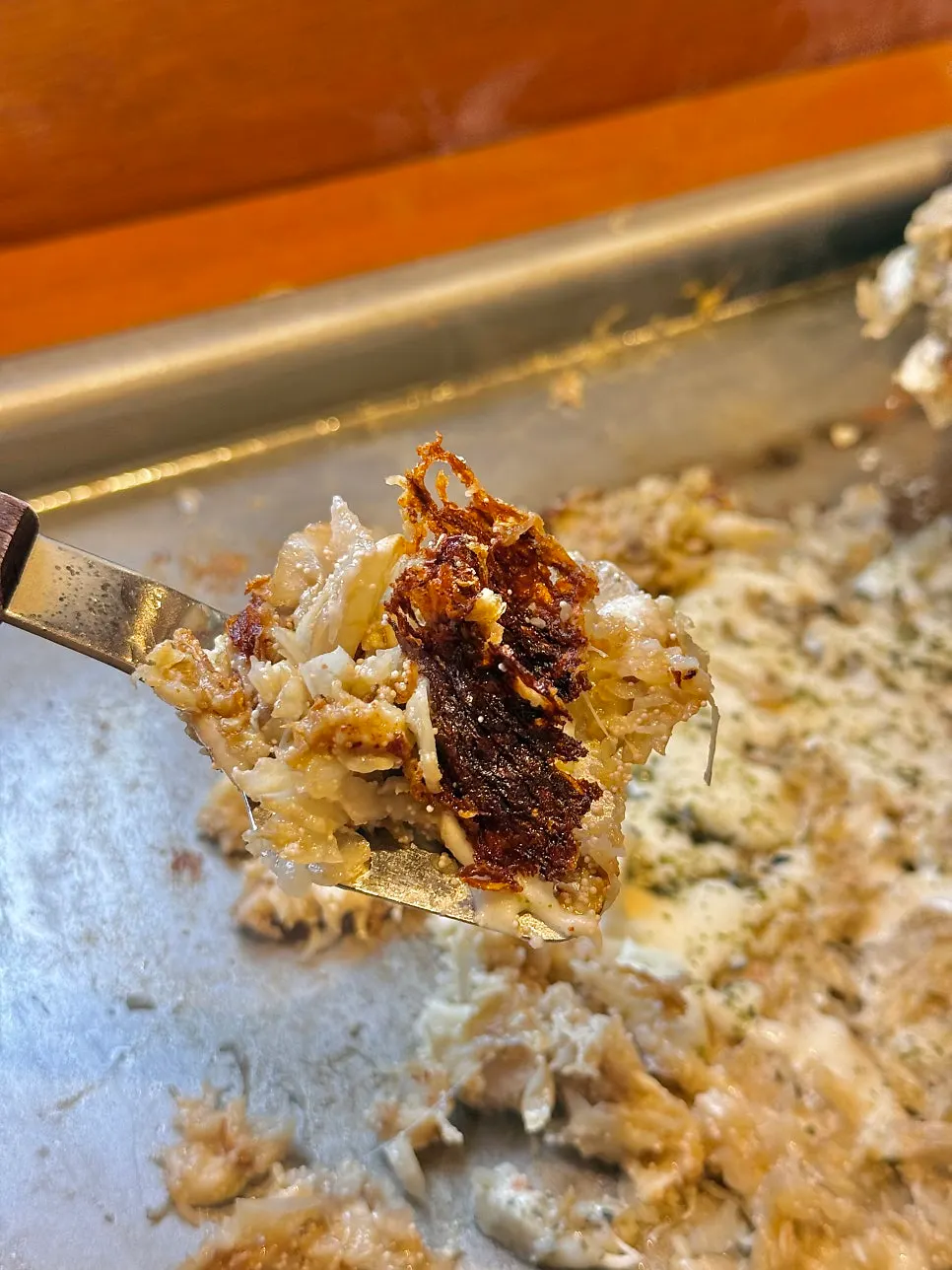 Scraping up monjayaki with a small spatula