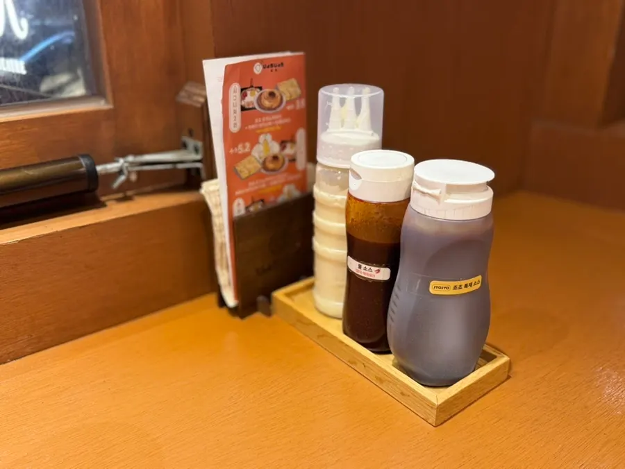 Mayonnaise, fire sauce, and Jojo's special sauce on the table